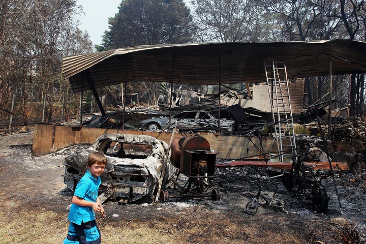 Lyndon Dunlop walks in the backyard of his grandparent’s home of 41 years destroyed by bushfire on October 21, 2013 in Winmalee, Australia. (Lisa Maree Williams/Getty Images)