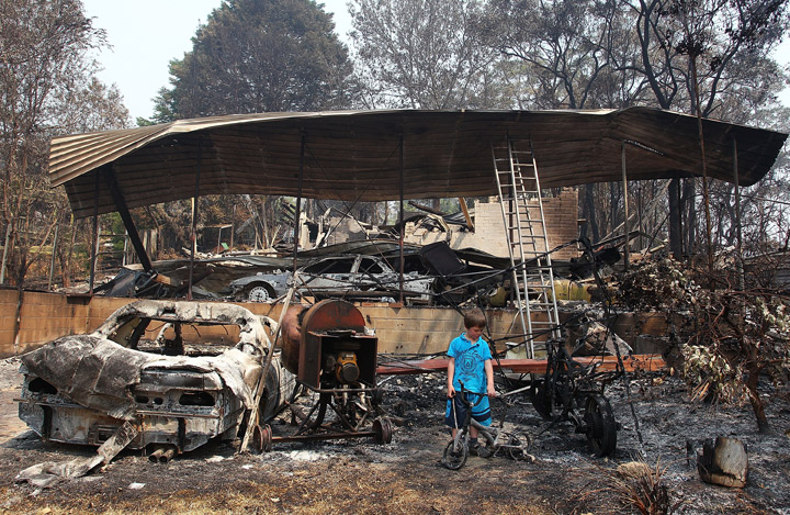 Lyndon Dunlop inspects the remains of of his grandparent’s home of 41 years destroyed by bushfire on October 21, 2013 in Winmalee, Australia. (Photo credit: Getty Images)