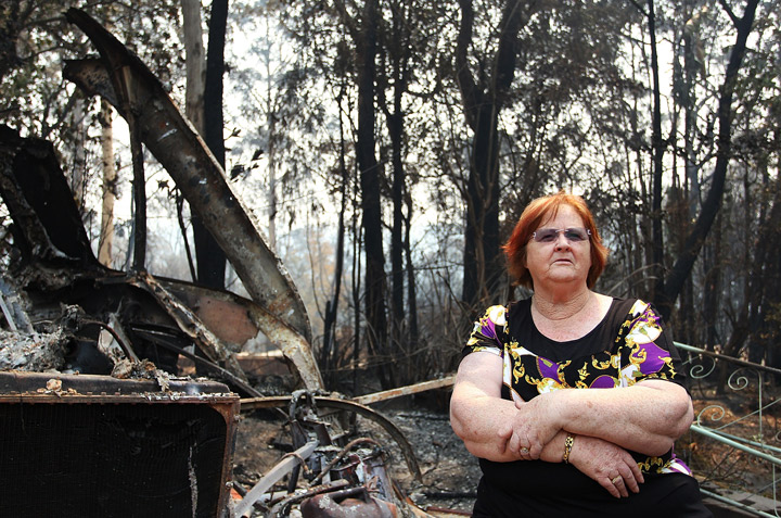 Sue Dunlop sits in the front yard of her home of 41 years which was destroyed by bushfire on October 21, 2013 in Winmalee, Australia. (Photo credit: Getty Images)