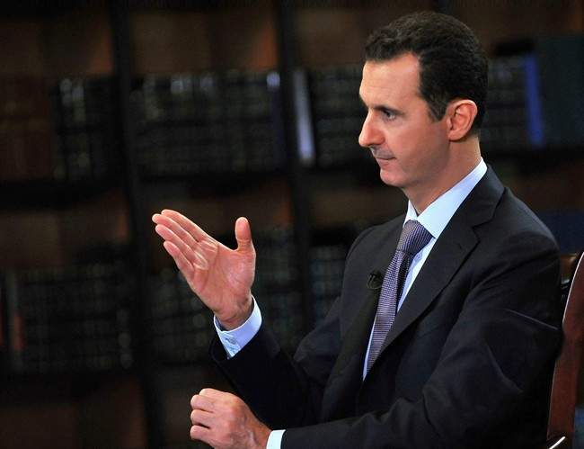 In this photo, which AP obtained from Syrian official news agency SANA, has been authenticated based on its contents and other AP reporting, President Bashar Assad gestures as he speaks during an interview with Italy's RAI News 24 TV, at the presidential palace in Damascus, Syria, Sunday, Sept. 29, 2013.