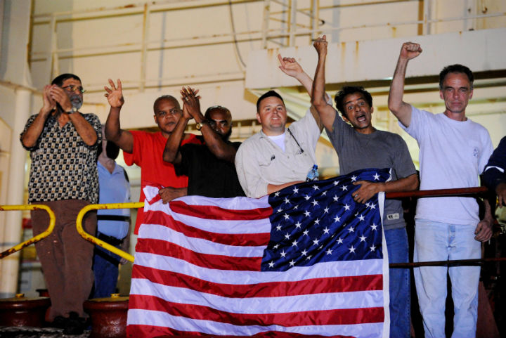 Crew members of the US merchant ship Maersk Alabama exault as they speak with the media moments after hearing that the captain of their ship which had been held captive by Somali pirates had been freed on April 12, 2009. (Photo by Roberto Schmidt/AFP/Getty Images)