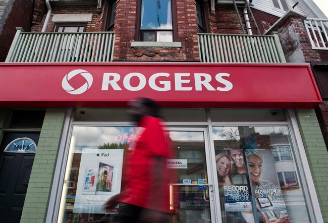 A man walks by a Rogers store in Toronto, Wednesday, August 15, 2013.