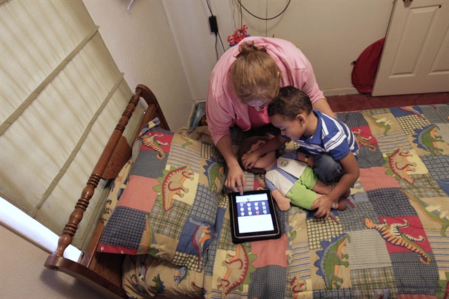 Denise Thevenot and her son Frankie Thevenot, 3, play with an iPad in his bedroom at their home in Metairie, La., on Oct. 21, 2011.