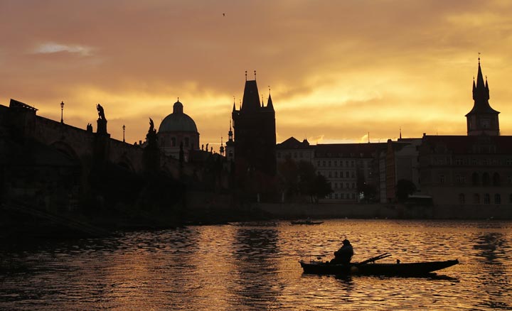 A fisherman waits for a catch underneath the medieval Charles Bridge as the sun rises in Prague, Czech Republic, Thursday, Oct. 17, 2013.  AP Photo/Petr David Josek.