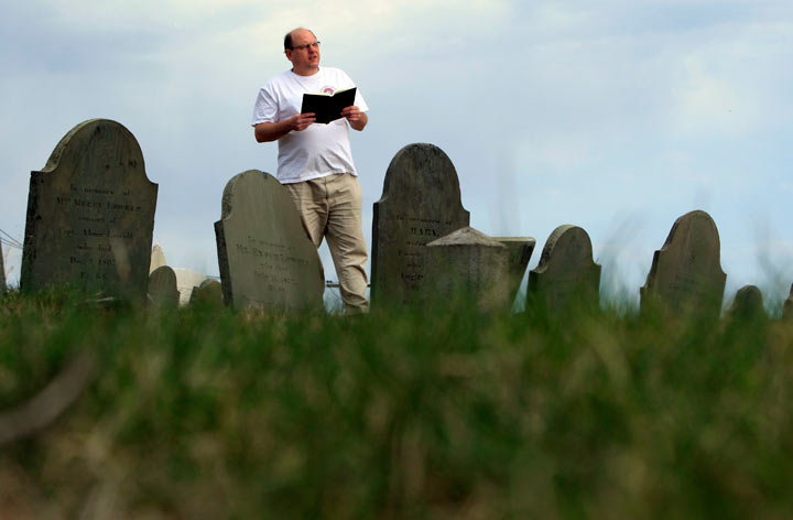 Walter Skold of Freeport, Maine, reads a Henry Wadsworth Longfellow poem while posing in Eastern Cemetery, Tuesday, April 20, 2010, in Portland, Maine.