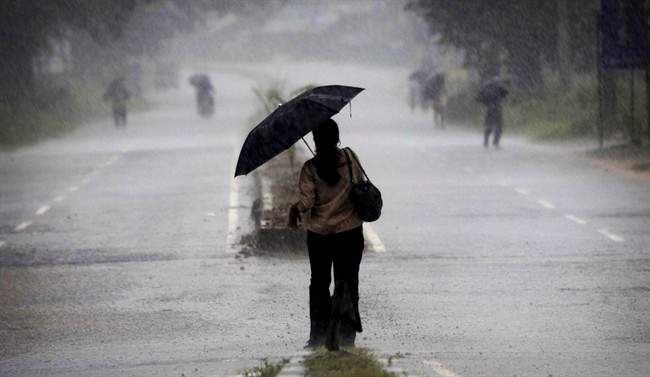 An Indian woman holds an umbrella as she heads towards a cyclone shelter near Chatrapur in Ganjam district about 200 kilometers (125 miles) from the eastern Indian city Bhubaneswar, India, Saturday, Oct. 12, 2013. 