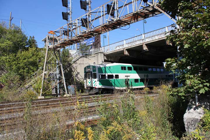 A GO train passes under the Dufferin Bridge