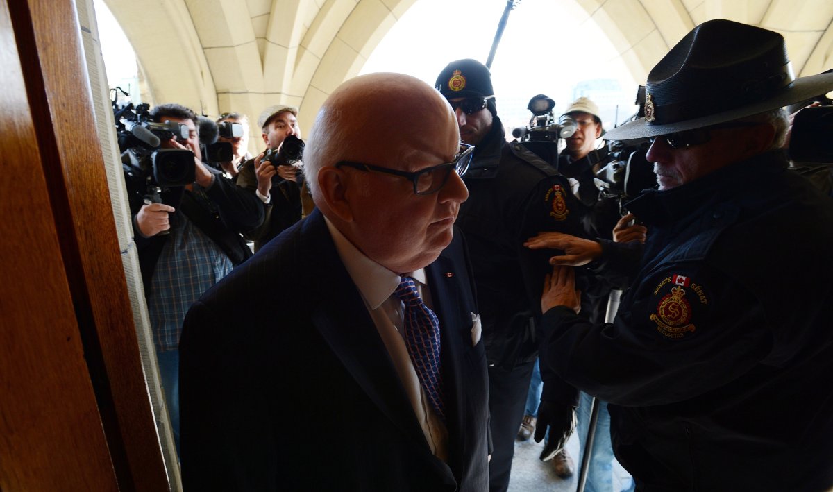 Sen. Mike Duffy arrives at the Senate on Parliament Hill in Ottawa on Tuesday, October 22, 2013. THE CANADIAN PRESS/Sean Kilpatrick.