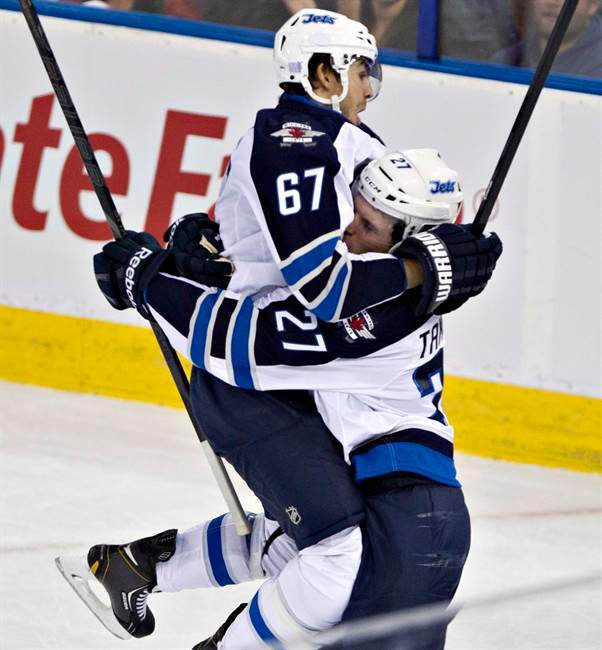 Winnipeg Jets' Michael Frolik (67) and Eric Tangradi (27) celebrate a goal against the Edmonton Oilers on Tuesday.