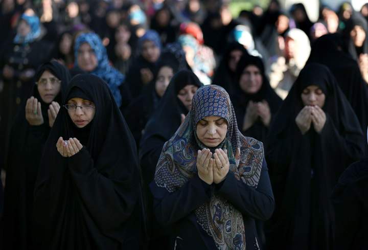Iraqi Shiite Muslim women attend the Eid al-Adha prayer, outside the party headquarters of the Supreme Islamic Council, in Baghdad, Iraq, Wednesday, Oct. 16, 2013. (Photo credit: AP Photo)