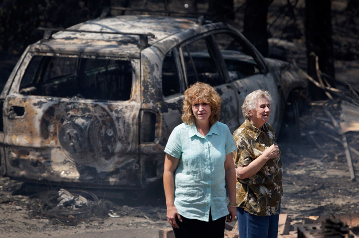 Leanne Brown and her mother Rosemary Booth inspect the remains of her home following severe bush fires on October 18, 2013 in Winmalee, Australia.