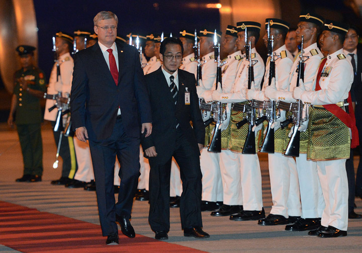 Prime Minister Stephen Harper is escorted by an official upon his arrival in Kuala Lumpur on Friday, October 4, 2013., to take part in a bilateral visit.