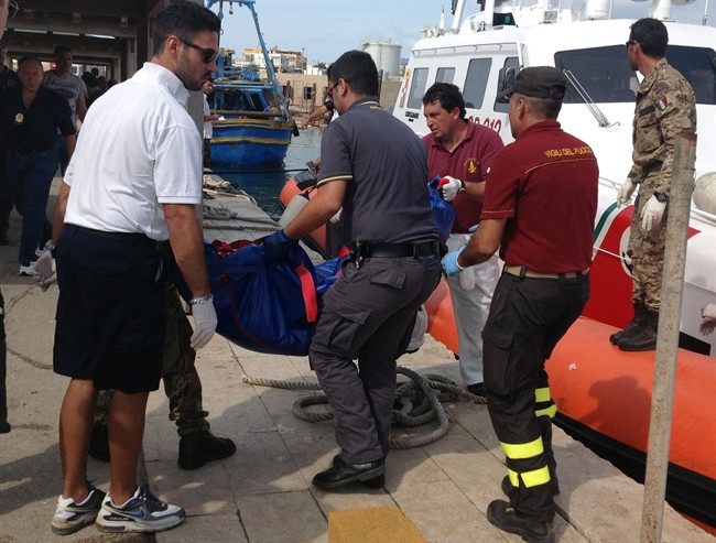 Firefighters unload the body of a drowned migrant from a Coast Guard boat in the port of Lampedusa, Sicily, Thursday, Oct. 3, 2013. Tens of people died when a ship carrying African migrants toward Italy caught fire and sank off the Sicilian island of Lampedusa, spilling hundreds of passengers into the sea, officials said Thursday. Many migrants have been rescued, but the boat is believed to have been carrying as many as 500 people. It is one of the deadliest migrant shipwrecks in recent times and the second one this week off Italy: On Monday, 13 men drowned while trying to reach southern Sicily when their ship ran aground just a few meters (yards) from shore at Scicli. 