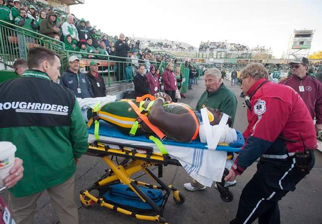 Edmonton Eskimos training staff check remove defensive tackle Almondo Sewell from the game after he was hit playing against the Saskatchewan Roughriders during the second half of CFL football action in Regina, Sask., Saturday, October 12, 2013.