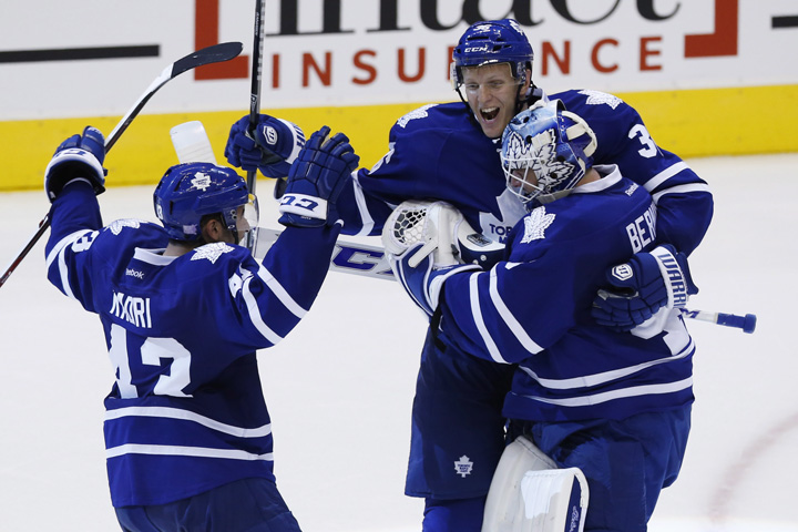 Toronto Maple Leafs' Jonathan Bernier, right, Carl Gunnarsson, centre, and Nazem Kadri celebrate defeating the Ottawa Senators in the shootout after NHL hockey action in Toronto, Saturday October 5, 2013. 