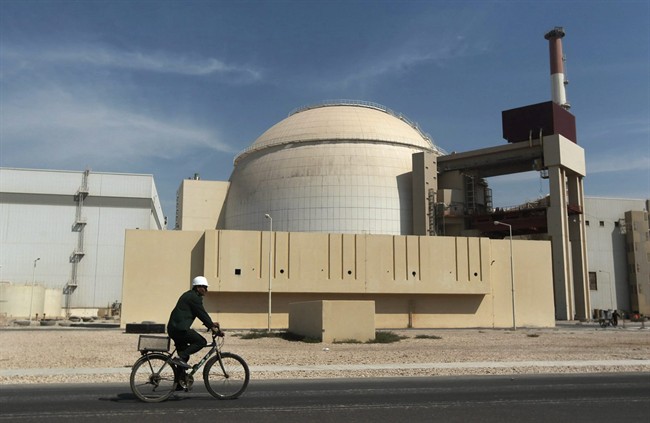 a worker rides a bicycle in front of the reactor building of the Bushehr nuclear power plant, just outside the southern city of Bushehr, Iran.