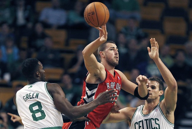 Toronto Raptors center Jonas Valanciunas (17), of Lithuania, passes as he is pressured by Boston Celtics forwards Jeff Green (8) and Kris Humphries during the first quarter of a preseason NBA basketball game, Monday, Oct. 7, 2013, in Boston.