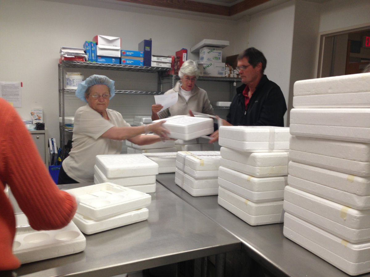 A small army of Meals on Wheels volunteers packing up food for delivery.