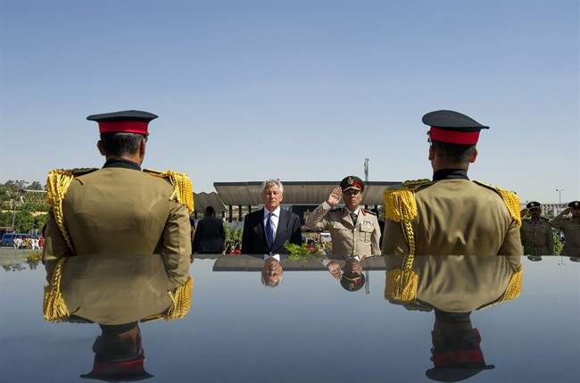 In this Wednesday, April 24, 2013, file photo, U.S. Secretary of Defense Chuck Hagel, second left, stands with an Egyptian army official before laying a wreath at the tomb of late President Anwar al-Sadat in Cairo. 