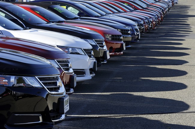 In this Wednesday, Sept. 18, 2013 photo Chevrolet passenger cars form a row on a dealer's lot in Needham, Mass. U.S.