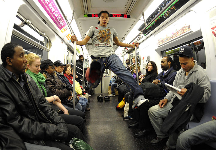 New York City Subway dancer Marcus Walden aka Mr Wiggles performs acrobatic tricks on the subway while passengers watch November 23, 2010.