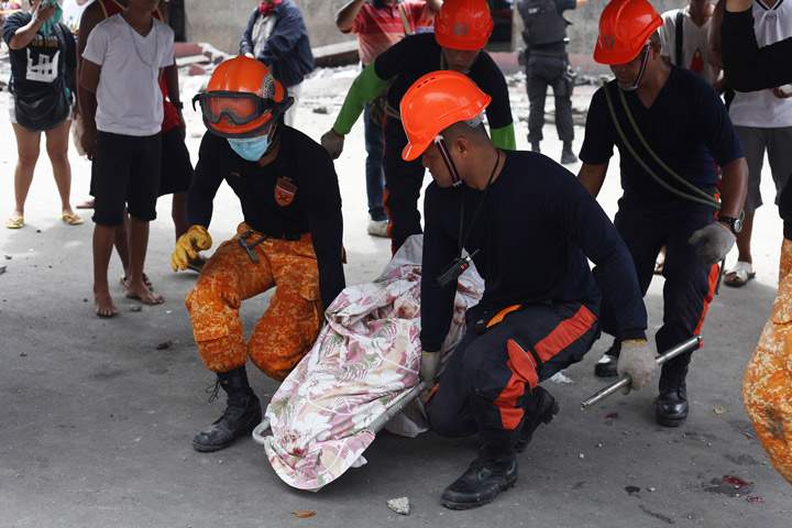 Rescue workers carry a victim’s body recovered from rubble in Cebu City, Philippines after a major 7.2 magnitude earthquake struck the region on October 15, 2013. (Photo credit: Getty Images)