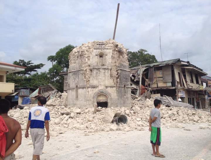 People walk past the damaged Church of San Pedro in the Philippine town of Loboc, Bohol after a major 7.2 magnitude earthquake struck the region on October 15, 2013. (Photo credit: Getty Images)