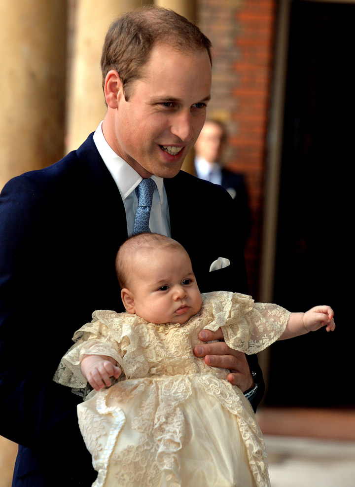 Prince William, Duke of Cambridge arrives, holding his son Prince George, at Chapel Royal in St James’s Palace, ahead of the christening of the three month-old Prince George of Cambridge by the Archbishop of Canterbury on October 23, 2013 in London, England. (Photo credit: Getty Images)