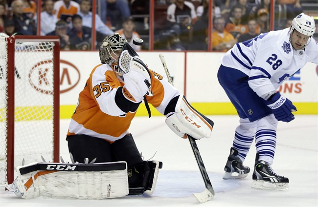 Philadelphia Flyers' Steve Mason, left, blocks a shot as Toronto Maple Leafs' Colton Orr looks on during the first period of an NHL hockey game on Wednesday, Oct. 2, 2013, in Philadelphia. 