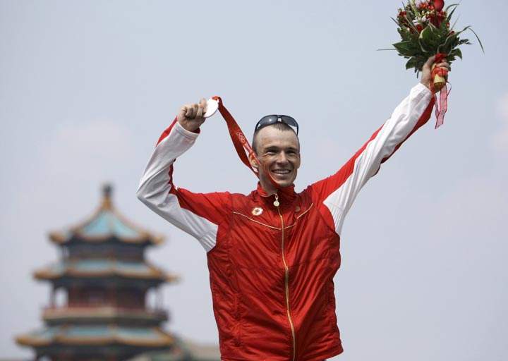 Canada's Simon Whitfield shows off his silver medal he won in the men's triathlon at the 2008 Beijing Olympics in Beijing Tuesday, Aug. 19, 2008. 