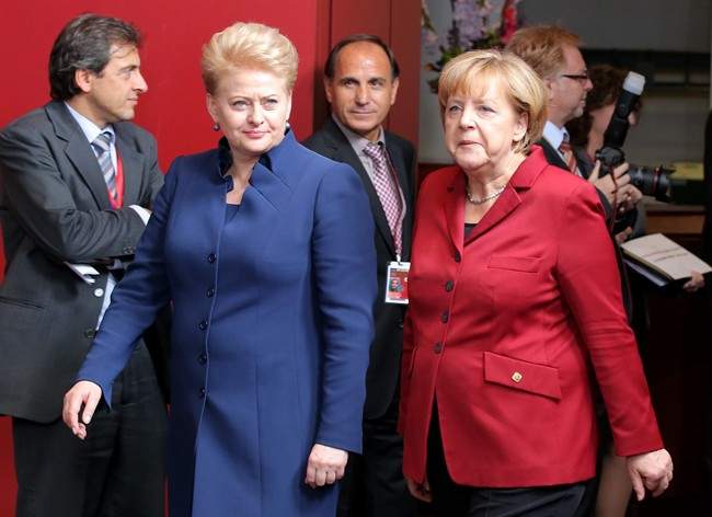 German Chancellor Angela Merkel, right, walks with Lithuanian President Dalia Grybauskaite, second left, prior to a group photo at an EU summit on Thursday, Oct. 24, 2013. 