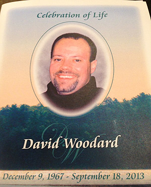 A funeral program is seen for Dave Woodard.