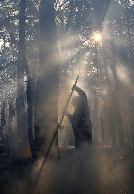 Firefighters mop up after a firestorm swept through a property in Bilpin, 75 kilometers (47 miles) from Sydney, Wednesday, Oct. 23, 2013. (Photo credit: AP Photo)