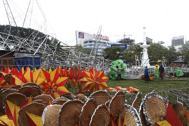 Workers examine the damage after a giant Christmas tree was toppled by strong winds at the onslaught of the powerful typhoon Haiyan. (AP Photo Chester Baldicantos)