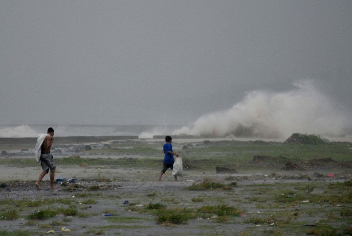 Residents sift through the shoreline amidst a storm surge brought about by powerful typhoon Haiyan at Legazpi city, Albay province. (AP Photo/Nelson Salting)