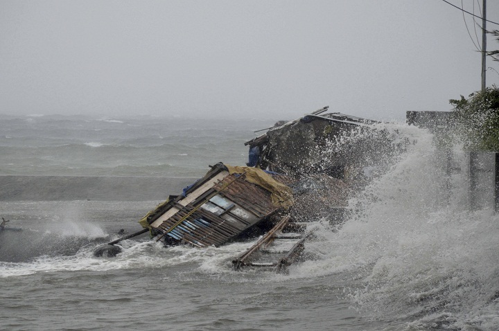 A house is engulfed by the storm surge brought about by powerful typhoon Haiyan that hit Legazpi city, Albay province. (AP Photo/Nelson Salting)