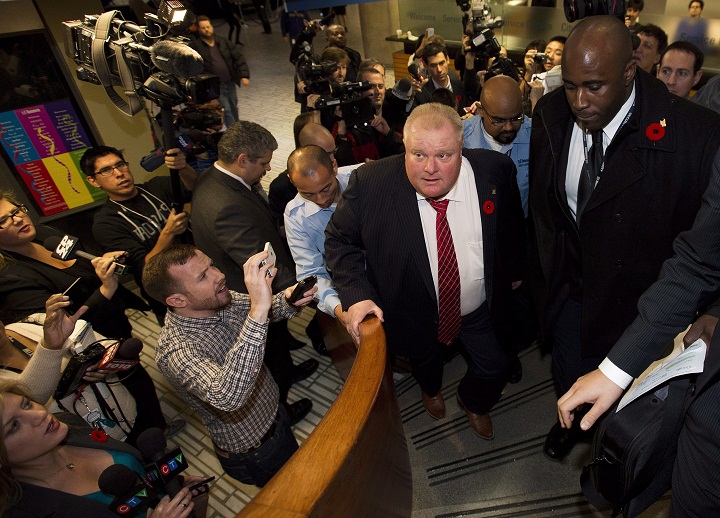 City of Toronto Mayor Rob Ford, right, his followed by a trail of reporters after he received his flu shot in Toronto on Friday, Nov. 8, 2013. 