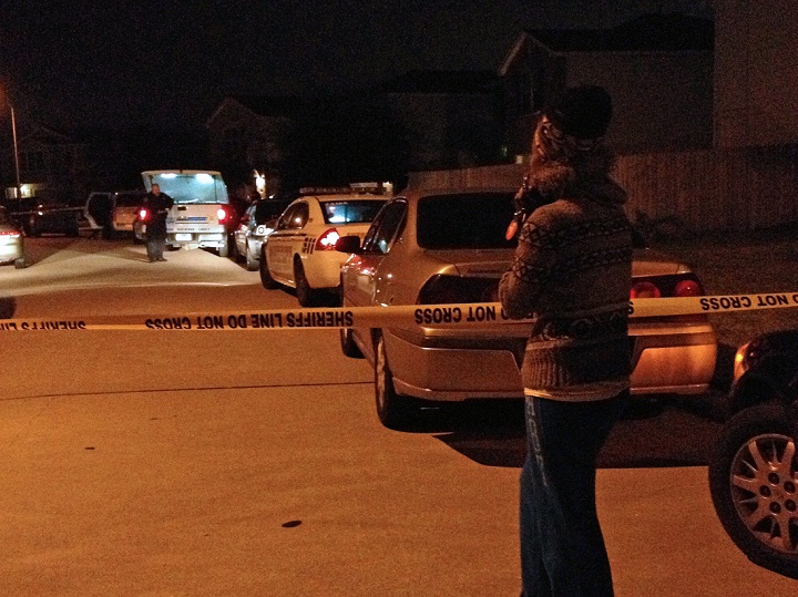 An unidentified parent waits on a child at the scene of a suburban Houston shooting early Sunday Nov. 10, 2013. Two people have been killed and at least 22 others hurt when gunfire rang out at the large house party in the Cypress-area of Houston, sending partygoers fleeing in panic, according to authorities.