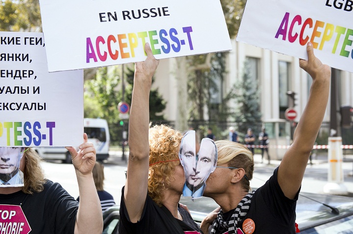 Demonstrators wearing masks depicting Russian President Vladimir Putin kiss and hold placards as they take part in a rally in front of the Russian embassy in Paris, on September 8, 2013, to protest against an 'anti-gay' Russian law. 