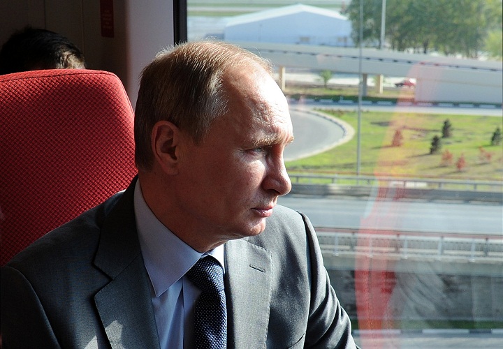 Russia's President Vladimir Putin travels by an aeroexpress train in the Russian Black Sea resort of Sochi, on October 28, 2013. With a race against the clock to complete building works, threats of militant attacks and a controversy over an anti-gay law, Russia faces an unprecedented challenge to defeat its sceptics and hold a successful Sochi Winter Olympics in 100 days time.