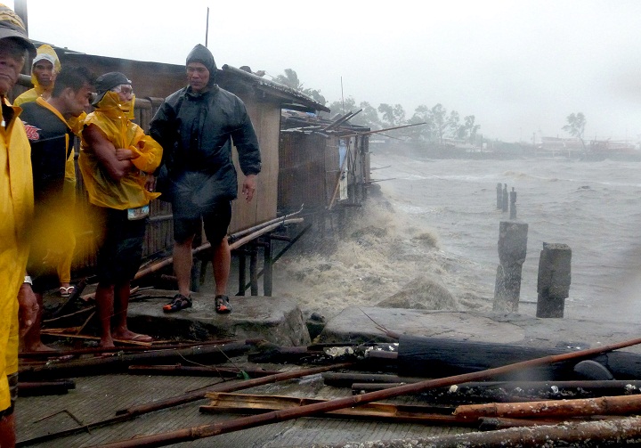 People stand at the pier as Super Typhoon Haiyan smashes into coastal communities on the central island of Bacalod. (JULIUS MARIVELES/AFP/Getty Images)