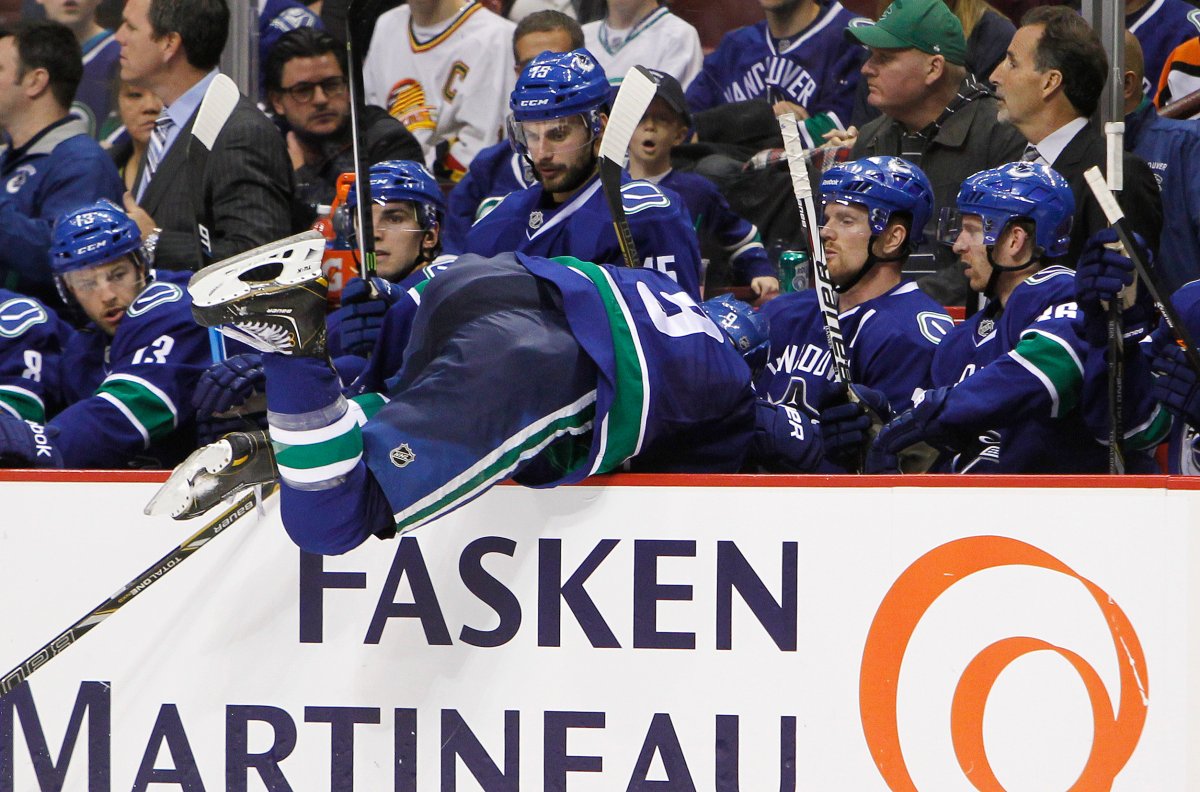 Zack Kassian of the Vancouver Canucks falls into his team's bench after missing a check against the Dallas Stars.  (Photo by Ben Nelms/Getty Images).