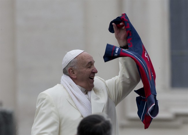 Pope Francis grabs a shirt thrown to him by faithful as he leaves at the end of his weekly general audience in St. Peter's Square at the Vatican, Wednesday, Nov. 27, 2013. 