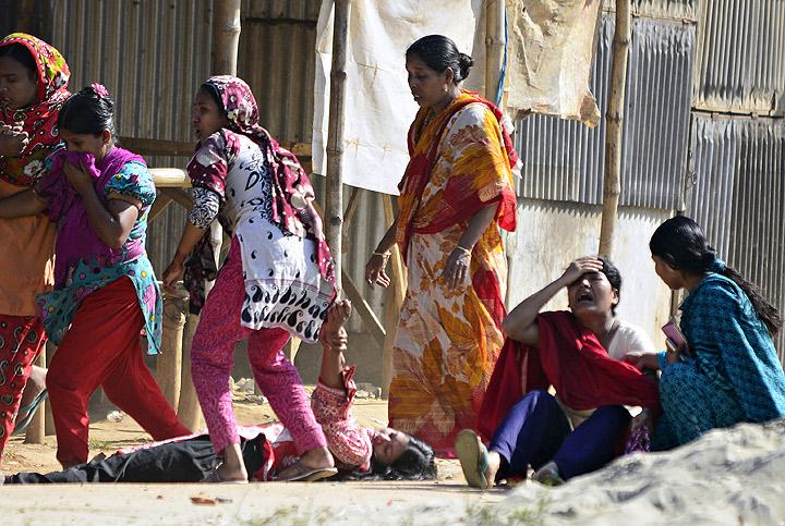 Bangladeshi garment workers are pictured on the ground as others react after riot police fired tear gas shells colleague during clashes in Ashulia, a key garment manufacturing hub outside Dhaka, on November 12, 2013. (Photo credit: Getty Images). Read the latest here.