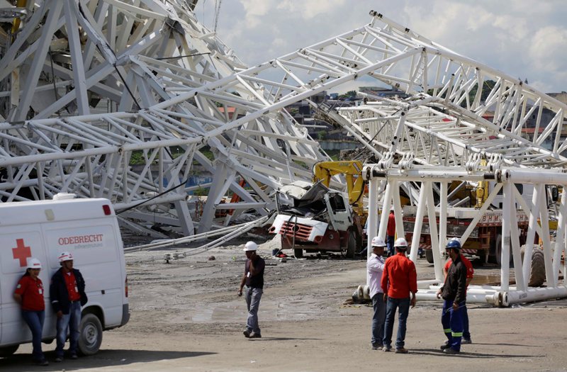 People stand near a metal structure that buckled on part of the Itaquerao Stadium in Sao Paulo, Brazil, Wednesday, Nov. 27, 2013. Part of the stadium that will host the 2014 World Cup opener in Brazil collapsed on Wednesday, causing significant damage and killing at least two people, authorities said. (AP Photo/Nelson Antoine).