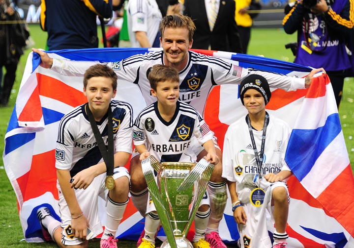 Picture taken on December 1, 2012 of David Beckham posing with his sons Brooklyn (L), Cruz (C) and Romeo and the MLS Trophy after the Los Angeles Galaxy beat Houston Dynamo 3-1 in the Major League Soccer (MLS) Cup in Carson. 