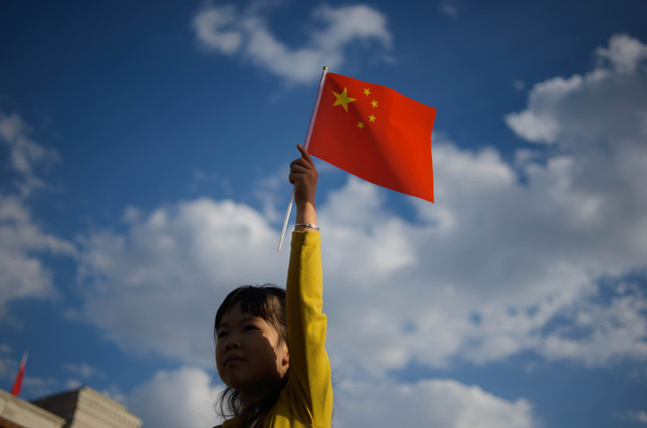 A girl waves a Chinese flag on Tiananmen Square in Beijing on October 1, 2013.  China has won a seat on the Human Rights Council, the U.N.'s highest rights watchdog body, upsetting independent human rights groups.