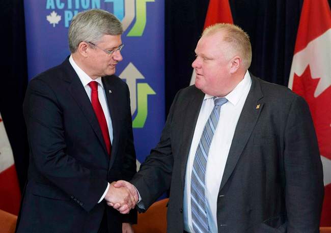 Prime Minister Stephen Harper shakes hands with Toronto Mayor Rob Ford after announcing funding for new subways in Toronto, Sunday, September 22, 2013. Harper appears to be among the few living souls with no opinion on the Toronto mayor's spectacular fall from grace.
