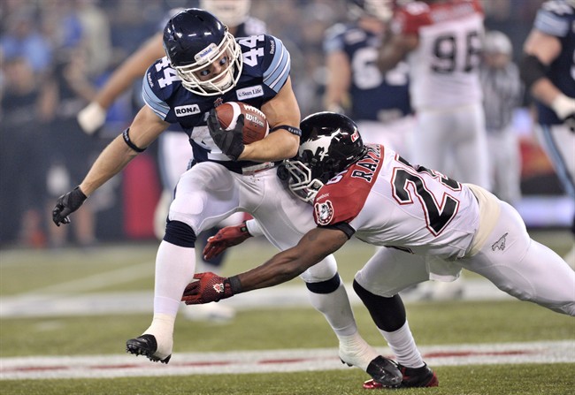 Toronto Argonauts running back Chad Kackert runs the ball against Calgary Stampeders defensive back Keon Raymond during the first quarter of the CFL Grey Cup Sunday November 25, 2012 in Toronto.