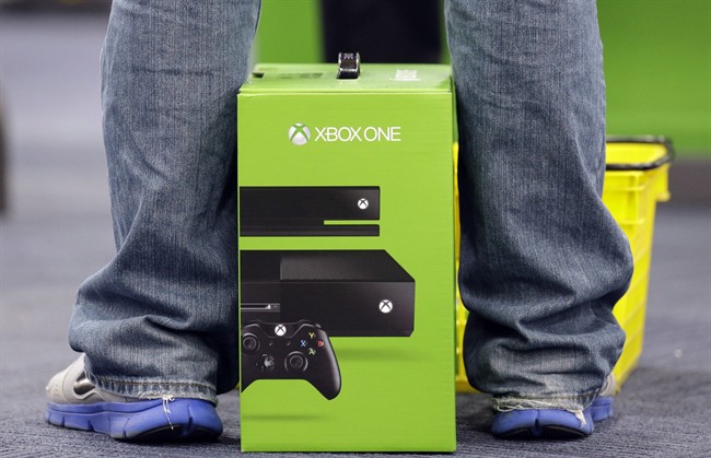 A man puts his newest XBox One on the floor after he purchased it at a Best Buy on Friday, Nov. 22, 2013., in Evanston, Ill.
